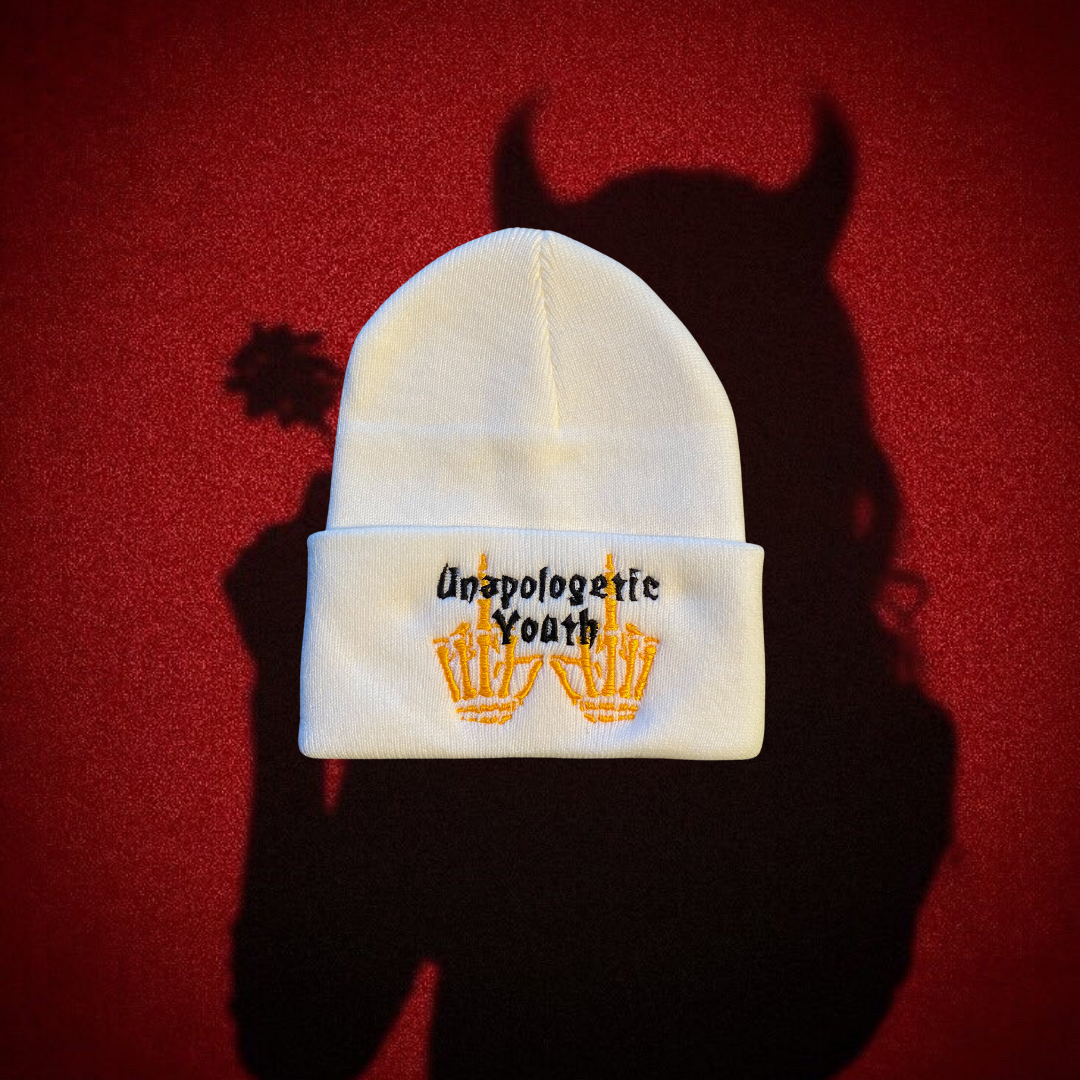 Unapologetic Youth "Cold World" white beanie with black embroidered logo, cozy knit fabric, and snug fit for cold weather.