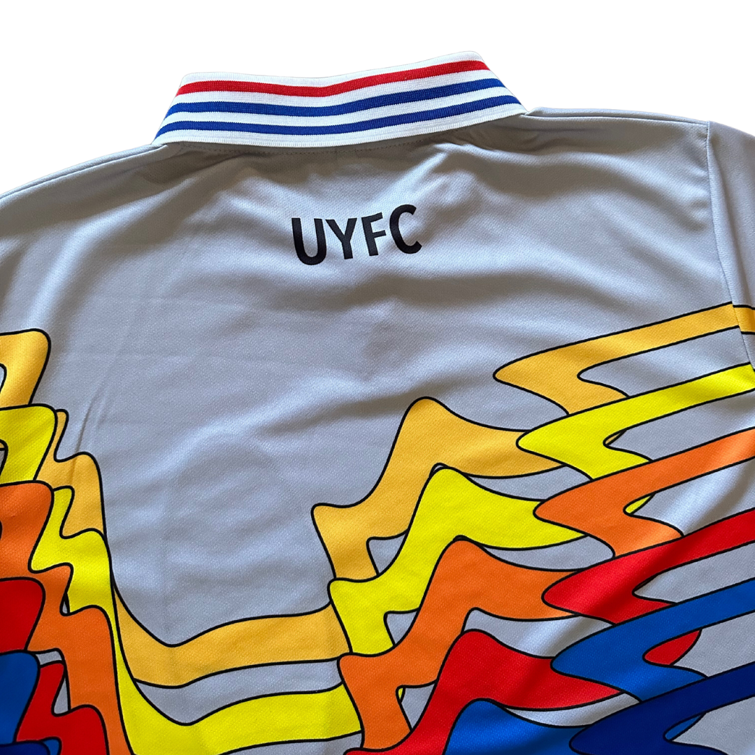 Unapologetic Youth UYFC home jersey featuring team logo and vibrant design, shown laid flat on a white background.