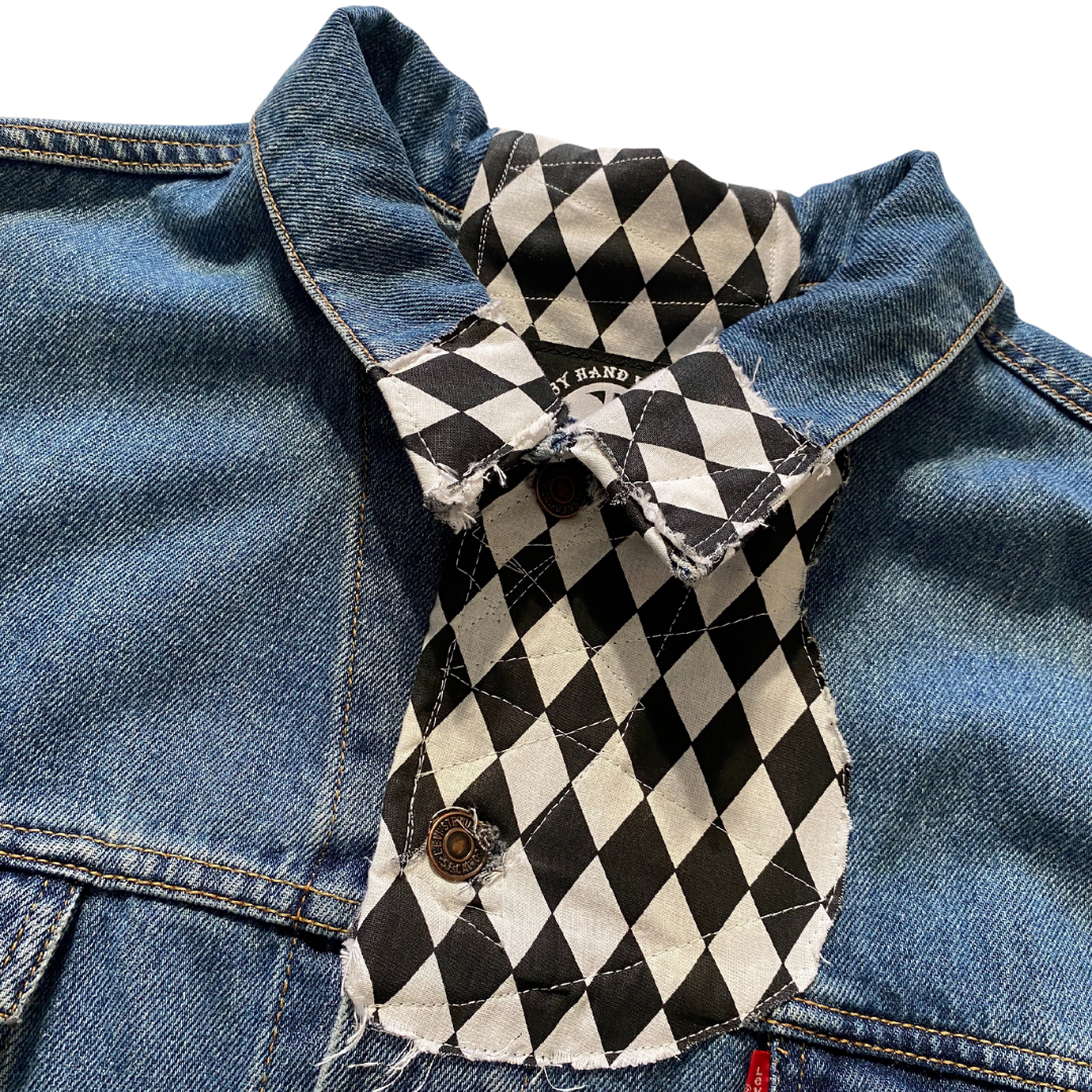 Unapologetic Youth Torn large/XL denim jacket with distressed details and classic fit, shown hanging on a wooden background.