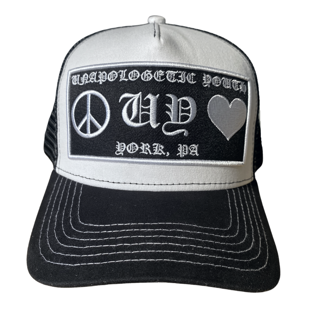 Unapologetic Youth Hearts trucker hat with embroidered red heart design, white mesh back and adjustable snap closure.