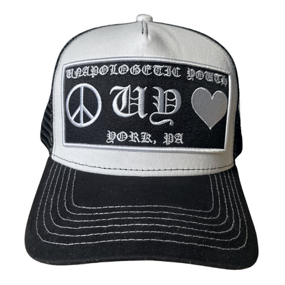 Unapologetic Youth Hearts trucker hat with embroidered red heart design, white mesh back and adjustable snap closure.
