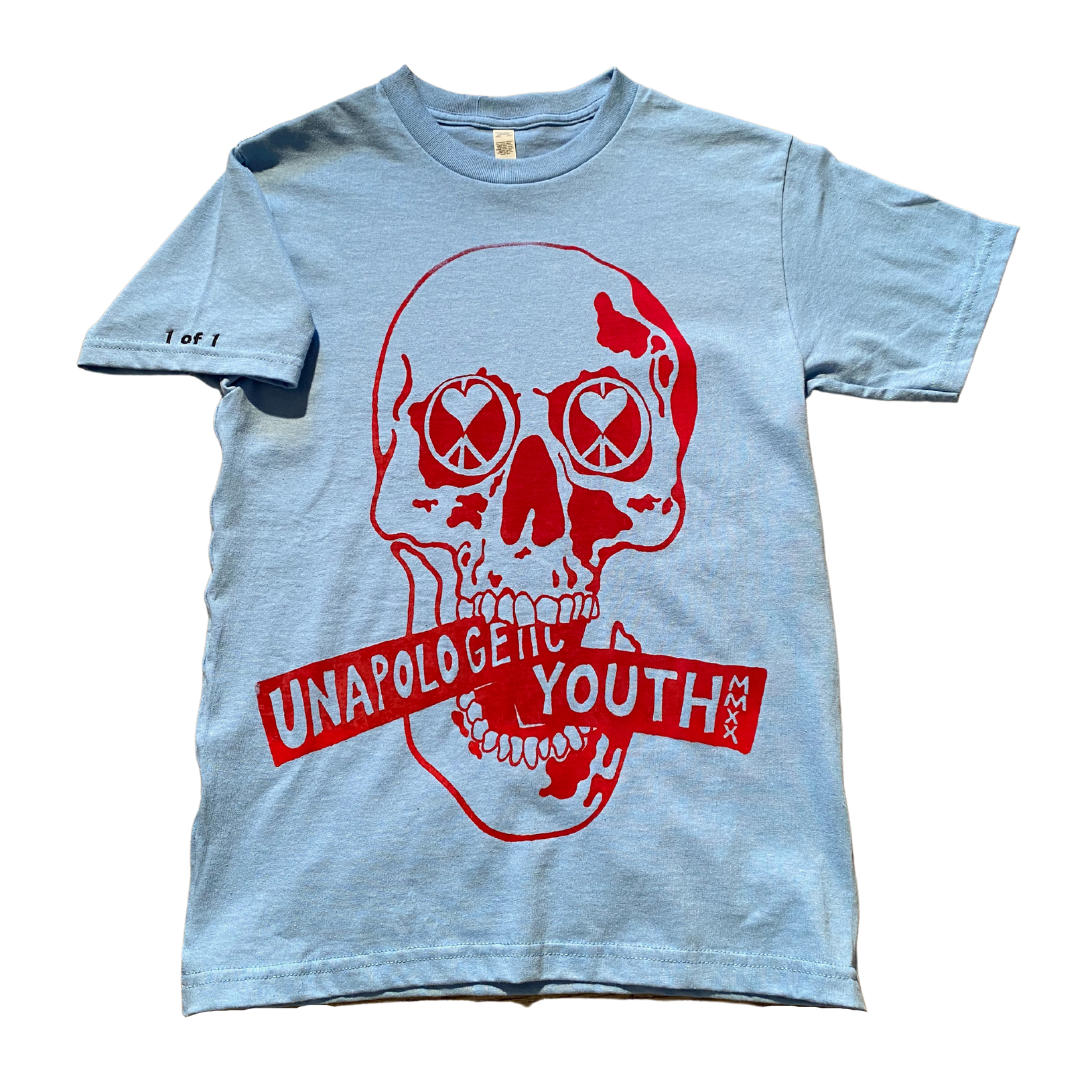 Baby blue Unapologetic Youth T-shirt laid flat, showcasing its soft fabric and simple design for kids or casual wear.
