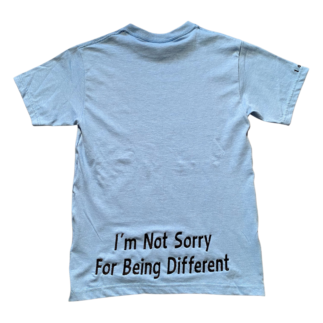 Baby blue Unapologetic Youth T-shirt laid flat showing front design and soft cotton fabric.