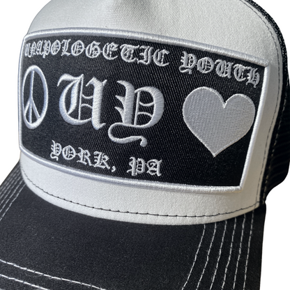 Unapologetic Youth Hearts trucker hat featuring a red heart design on white mesh, adjustable snapback closure.