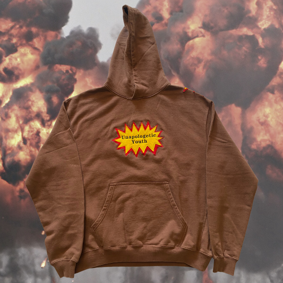 Unapologetic Youth War Torn hoodie featuring a distressed design, black fabric, and a relaxed fit displayed on a hanger.