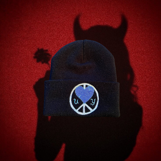 Black Unapologetic Youth "Cold World" beanie with bold white text, cozy knit material, and a snug fit.