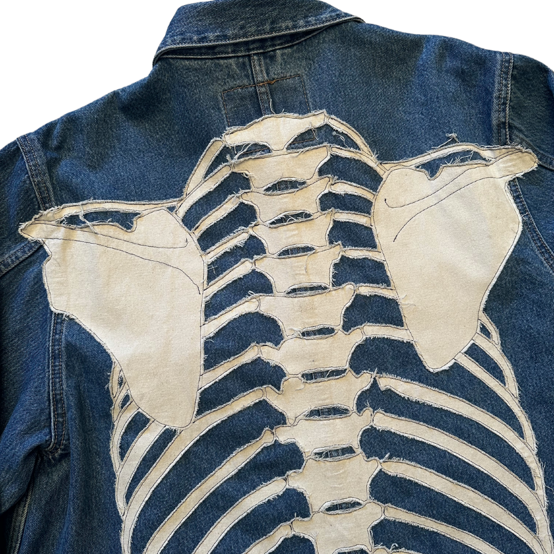 Unapologetic Youth denim jean jacket with distressed bones design, long sleeves, classic collar, and button closure.