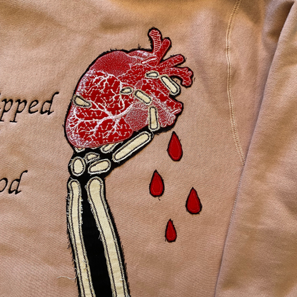 Black hoodie from Unapologetic Youth featuring "Bleeding Love" graphic print on the front, casual and comfortable streetwear style.