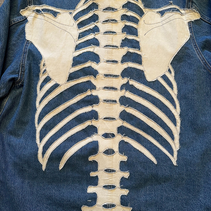 Unapologetic Youth denim jean jacket with bones design, featuring classic fit and button-up front, casual streetwear style.