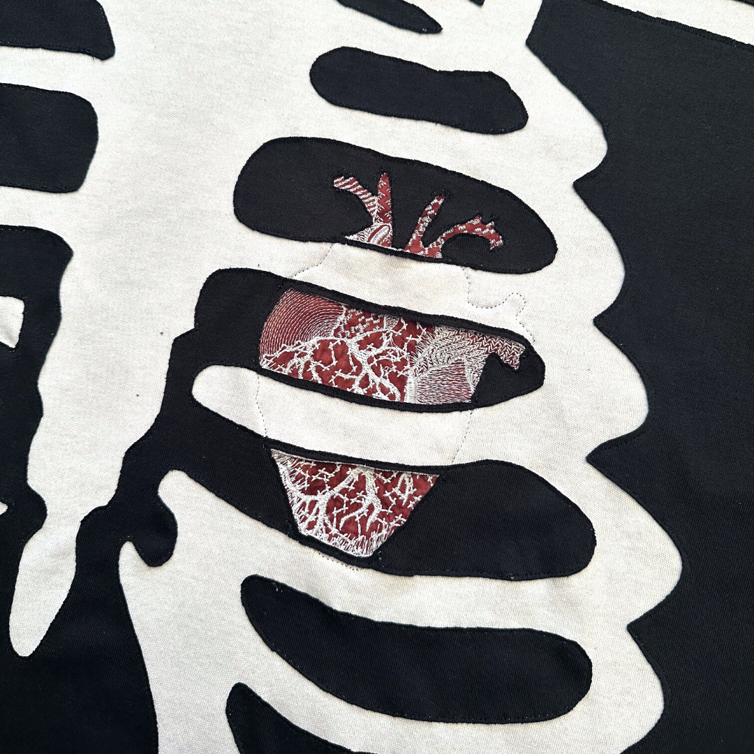 Unapologetic Youth long sleeve Bones T-shirt with a graphic design featuring skull bones on the front.