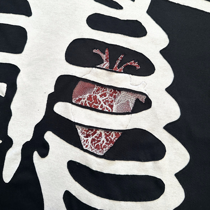 Unapologetic Youth long sleeve Bones T-shirt with a graphic design featuring skull bones on the front.