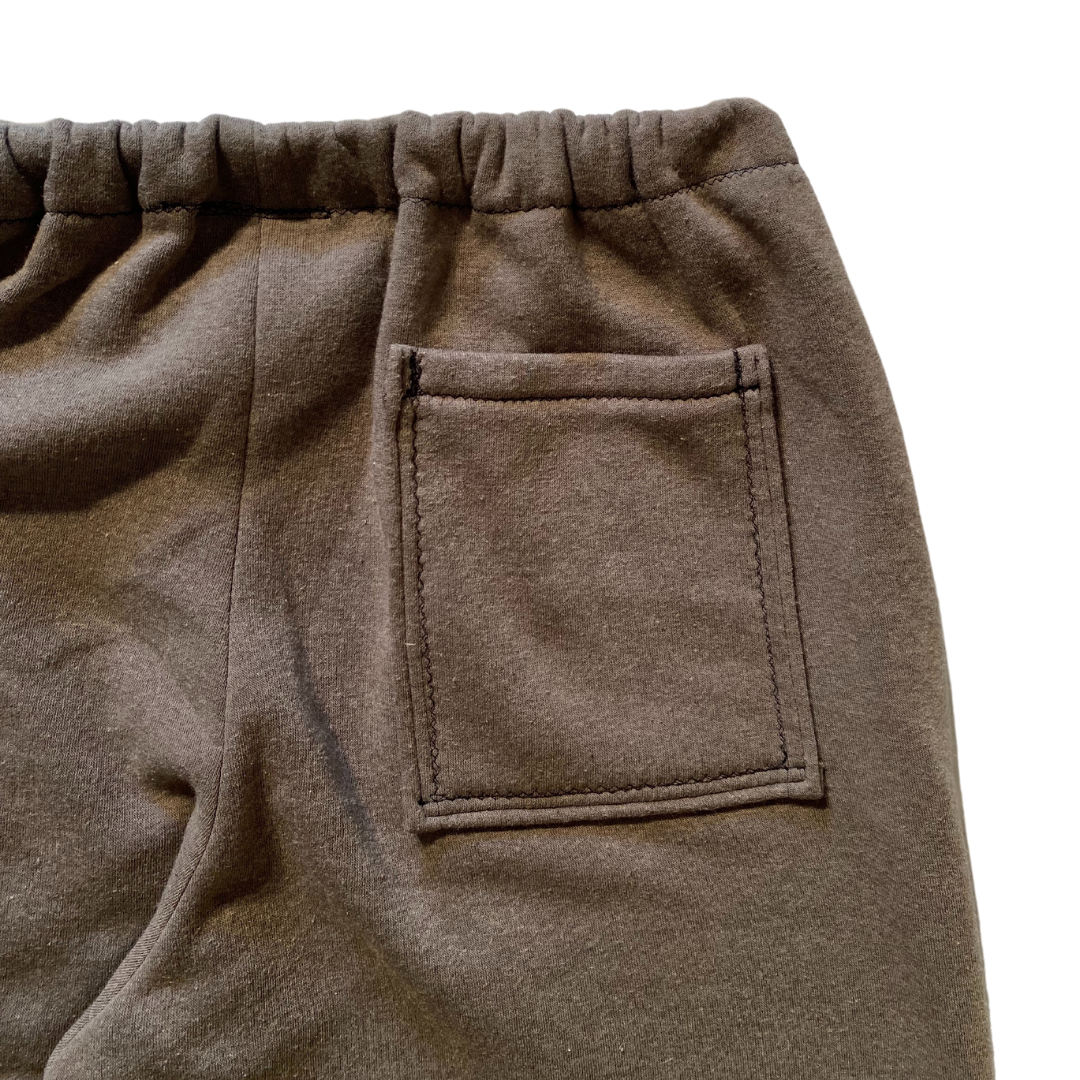 Unapologetic Youth F*cked medium sweatpants with bold logo text, relaxed fit, and soft fabric, shown in a casual setting.