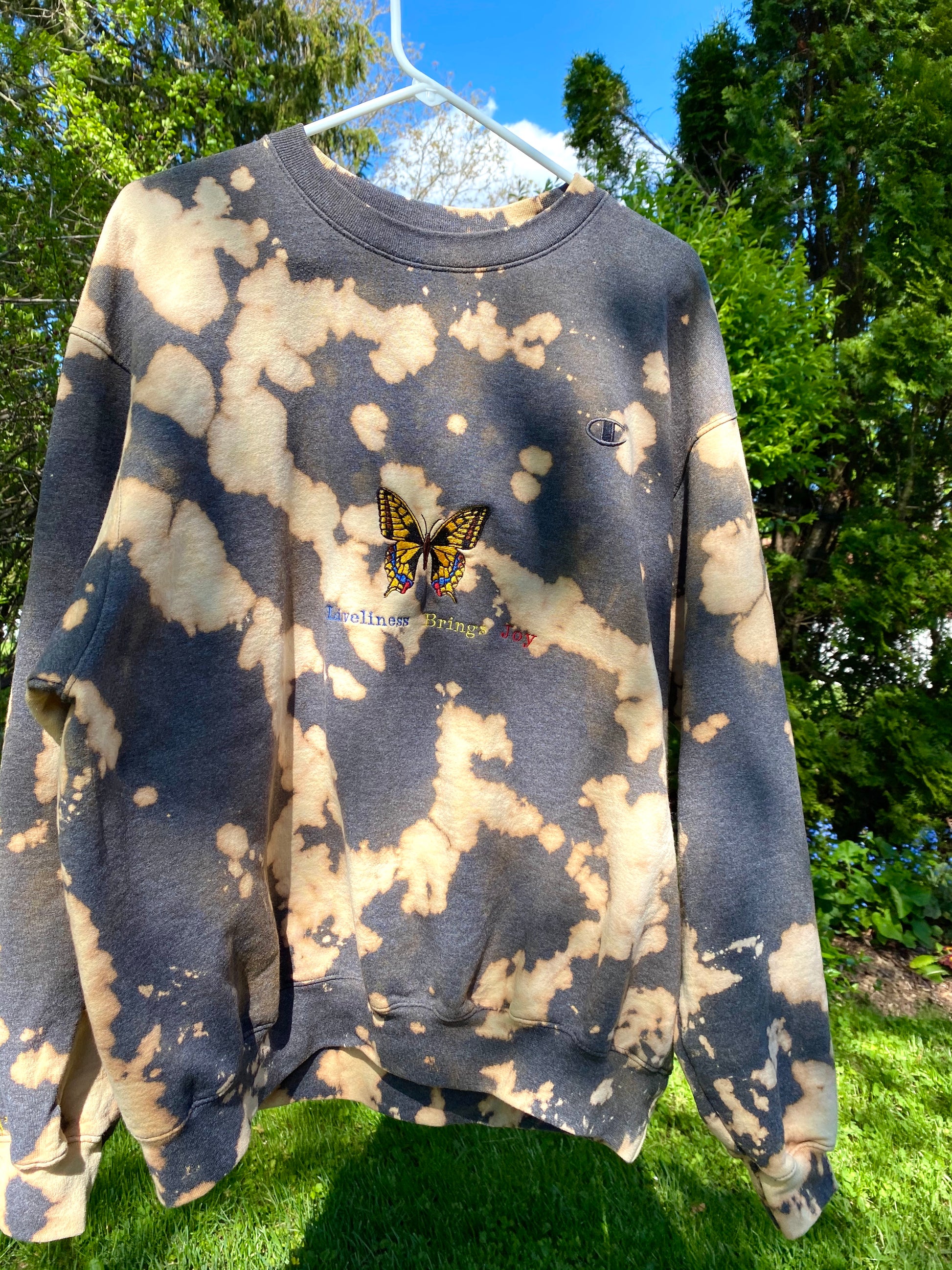 Unapologetic Youth x Champion crewneck sweatshirt with "Bring More Joy" graphic, soft fabric, and comfortable fit.