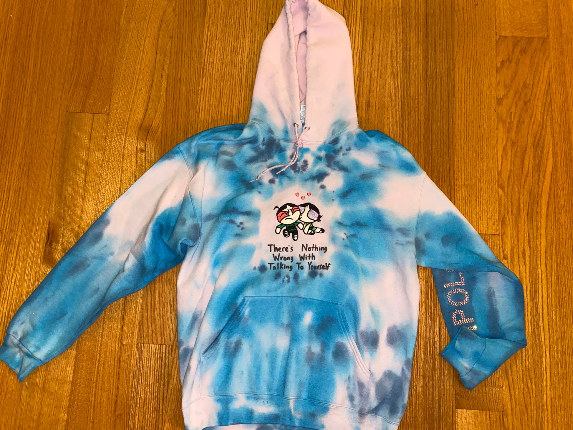 Black Unapologetic Youth "Nothings Wrong" sweatshirt with front logo and casual fit, displayed on a hanger.